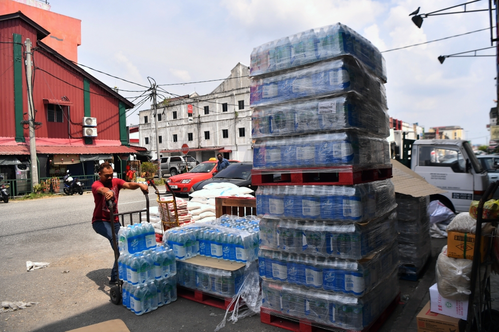 Wholesale workers stack bottled mineral water for sale in Pekan Teluk Intan February 13, 2025. — Bernama pic