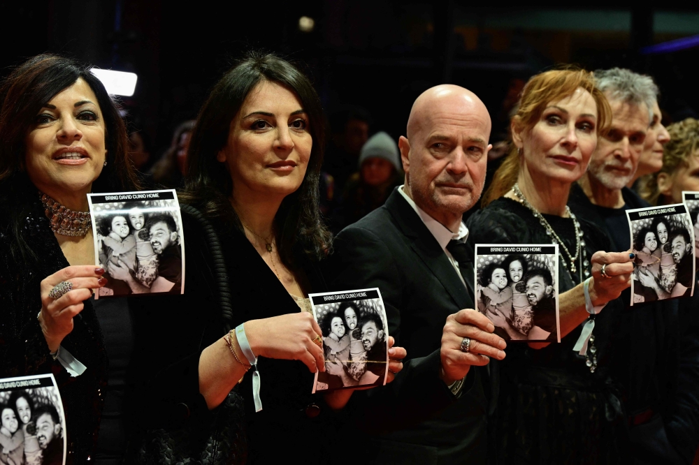 (From 2nd left) Human rights activist Duzen Tekkal, German actor Christian Berkel, German actress Andrea Sawatzki, actress, German actor Ulrich Matthes and Tricia Tuttle Berlinale director pose on the red carpet with photos of Israeli hostage David Cunio prior the opening ceremony and the screening of the film ‘Das Licht’ (The light) in the ‘Berlinale special’ section of the 75th Berlinale, Europe’s first major film festival of the year, in Berlin on February 13, 2025. — AFP pic
