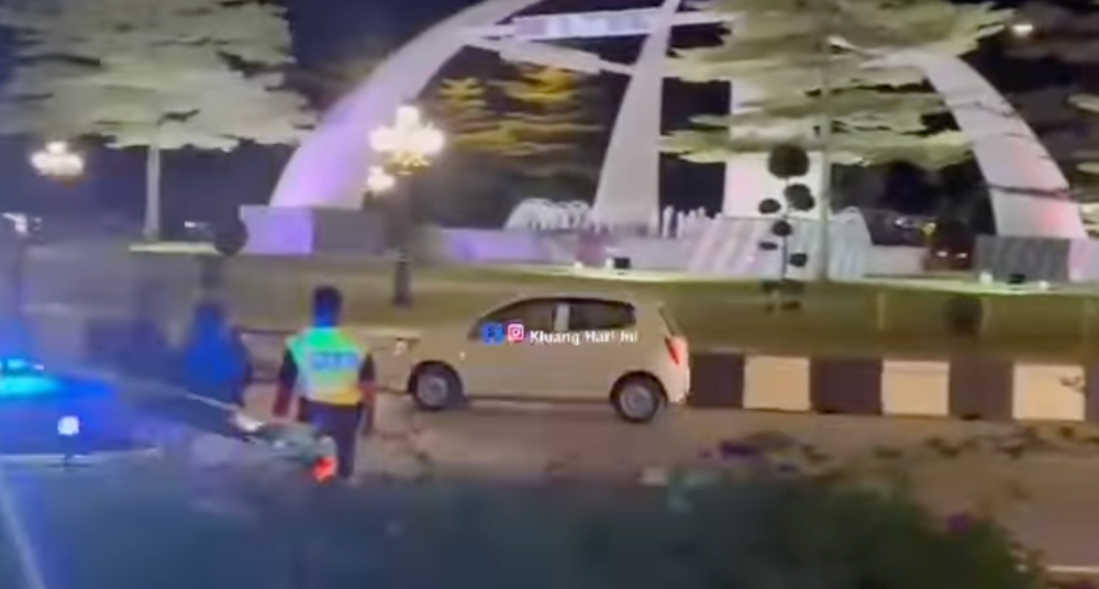 A screengrab from the viral 57-second video showing the white Axia repeatedly circling Bulatan Mahkota with its hazard lights flashing, allegedly from morning until night.