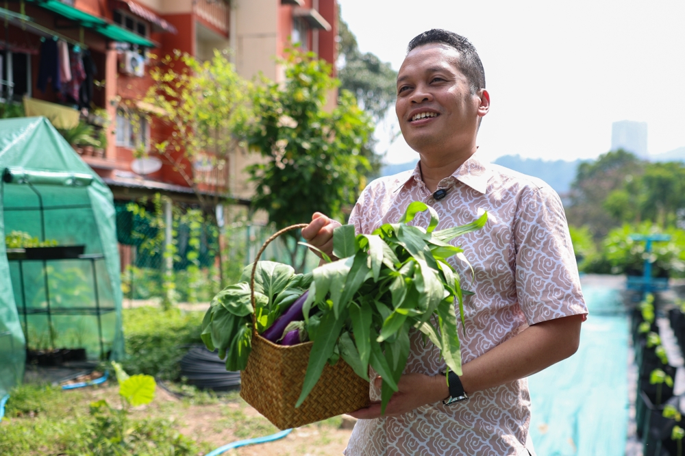 Natural Resources and Environmental Sustainability Minister Nik Nazmi Nik Ahmad holds a basket of harvested crops at the launch of the Urban Farm Project and the Bookstore & Stationery Project under the SejaTi Madani Community Well-being Programme in Setiawangsa February 15, 2025. — Bernama pic