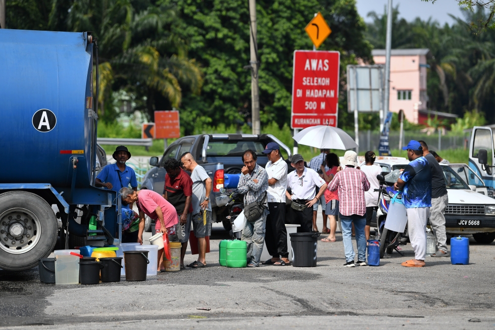 People queue to collect water from a tanker in Pekan Langkap, Teluk Intan February 13, 2025. — Bernama pic