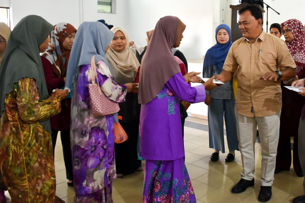 Datuk Rahmad Mariman (right) presents Zakat Fitrah and Fidyah aid to 8,781 households in Melaka on February 9, 2025. — Bernama pic