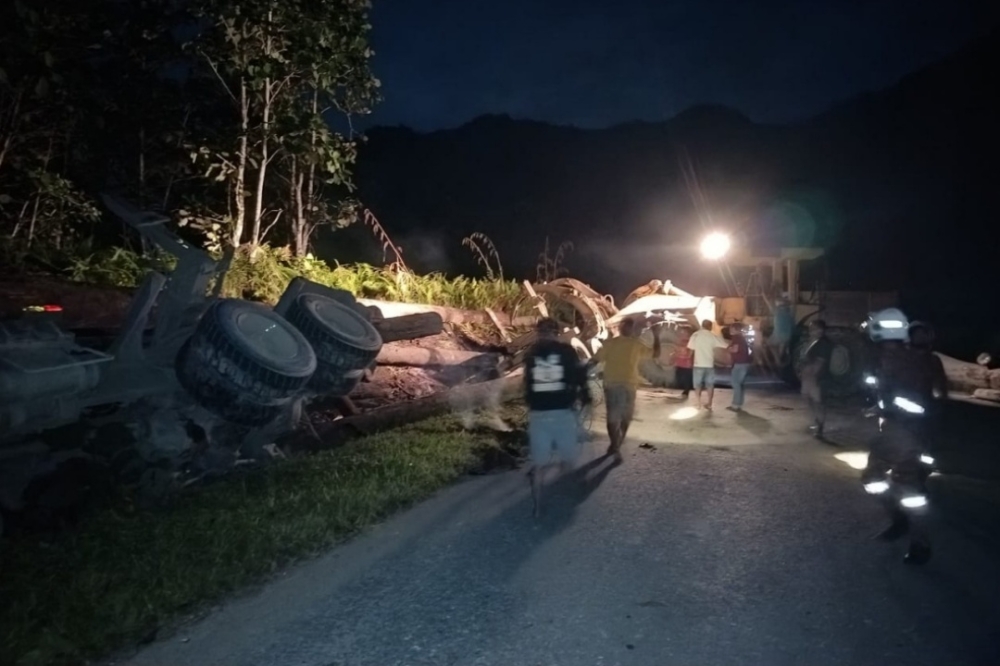 Handout photo shows workers removing the logs to enable Bomba personnel to recover the victim. — Picture courtesy of the Fire and Rescue Department 
