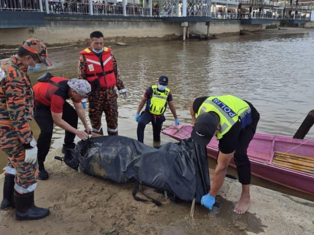 Firefighters and police personnel retrieving the body. — Picture courtesy of police