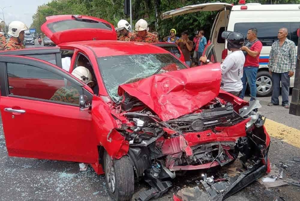 A 69-year-old woman died after her car collided with a lorry while she was taking her injured son to Hospital Jitra at the Hosba traffic light intersection in Jitra yesterday. — Picture courtesy of the Fire and Rescue Department