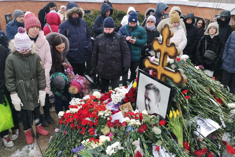 People pay tribute to late Russian opposition leader Alexei Navalny at his grave at the Borisovo cemetery, marking the first anniversary of his death while incarcerated in a remote Arctic penal colony, in Moscow on February 16, 2025. — AFP pic