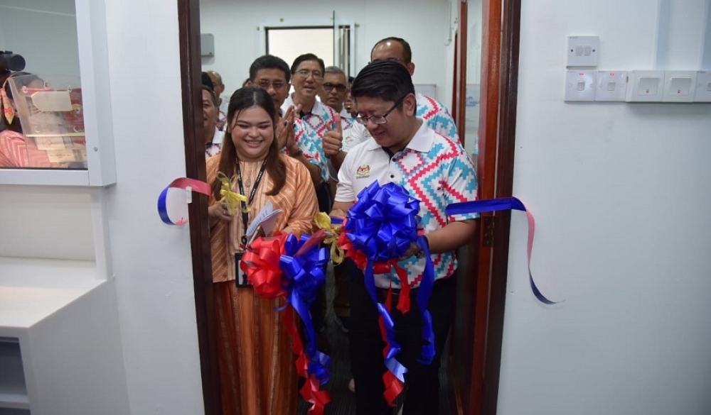 Nur Azre and Ewon cutting the ribbon to symbolise the opening of the TikTok Shop LIVE Hub on Sunday. — The Borneo Post pic