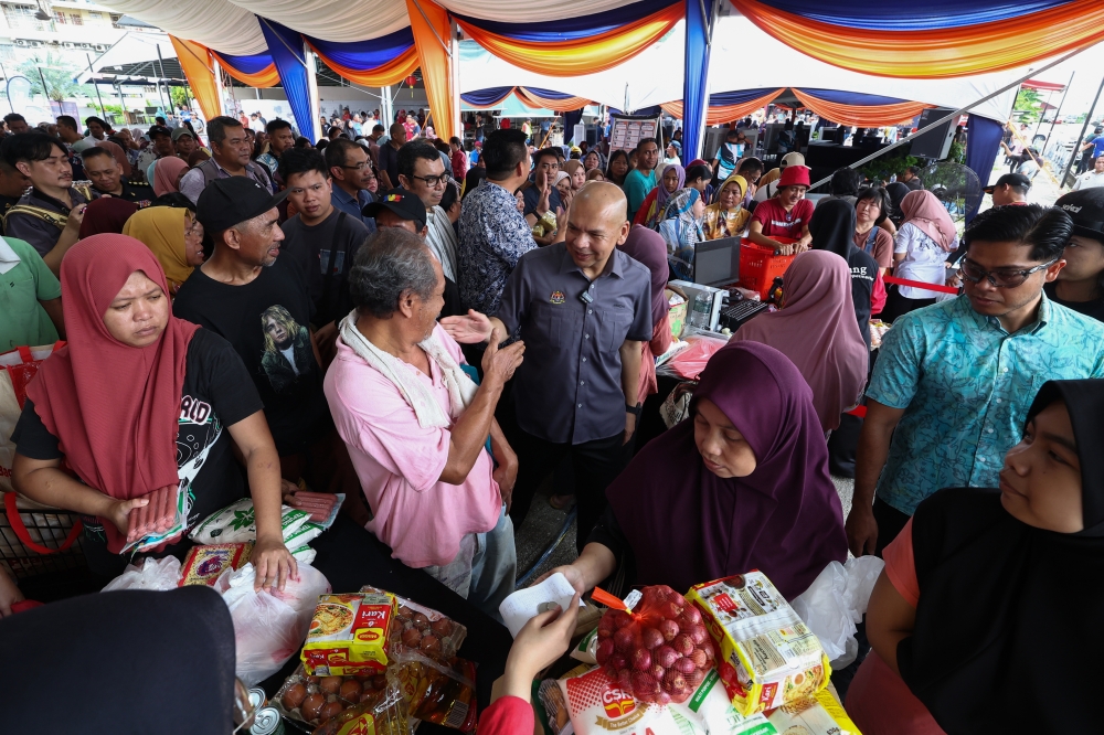Domestic Trade and Cost of Living Minister Datuk Armizan Mohd Ali interacts with members of the public during the Rahmah Madani Sales Programme for Batu Sapi and Karamunting constituencies in Sandakan February 16, 2025. — Bernama pic
