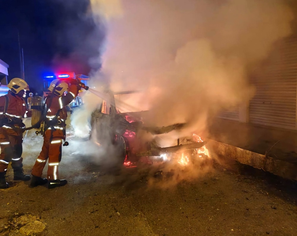 Firefighters work to extinguish the SUV fire. — Picture courtesy of the Fire and Rescue Department 