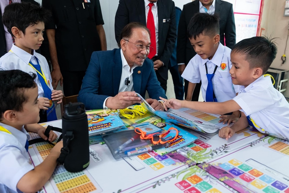 Prime Minister Datuk Seri Anwar Ibrahim speaks to school pupils during a visit to Sekolah Kebangsaan Kampung Baru February 17, 2025. — Picture via Facebook/Anwar Ibrahim 