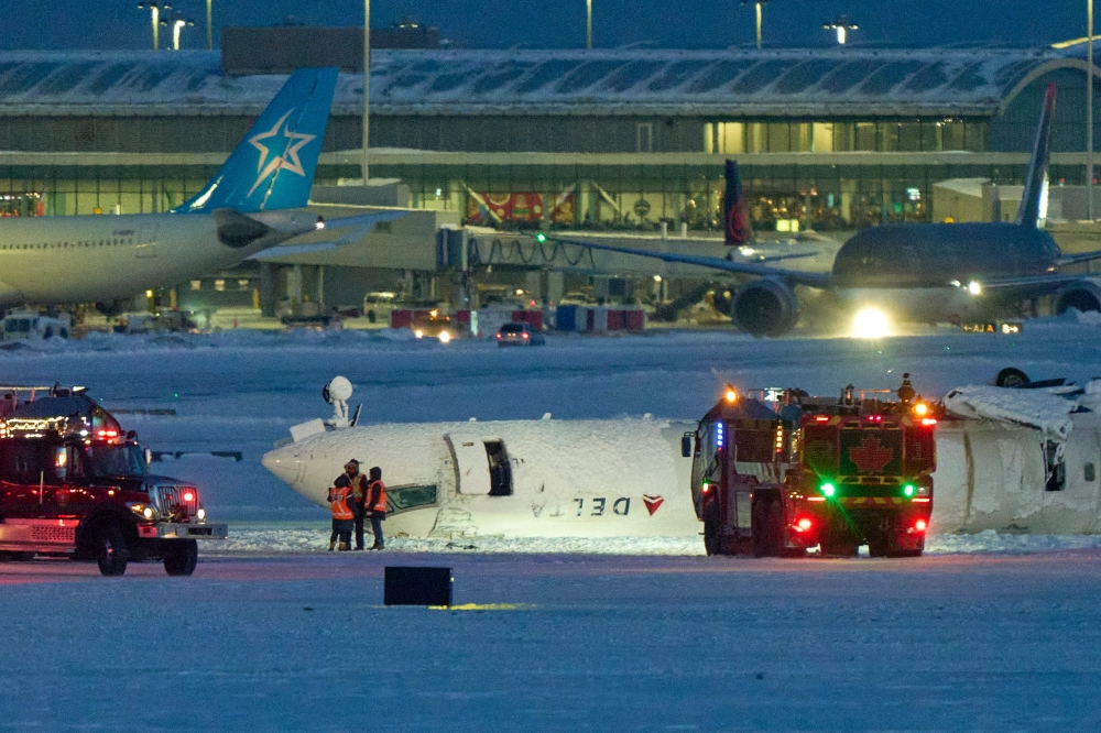 A Delta airlines plane sits on its roof after crashing upon landing at Toronto Pearson Airport in Toronto, Ontario, on February 17, 2025. — AFP pic