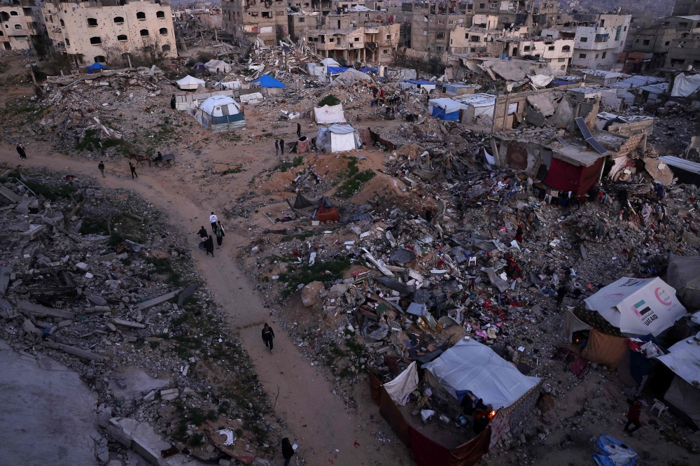 Palestinians camp amid the ruins of their houses in Jabalia in the northern Gaza Strip on February 17, 2025, as people return to northern parts of Gaza during a current ceasefire deal in the war between Israel and Hamas. Israeli Prime Minister Benjamin Netanyahu said on February 17, that he was ‘committed’ to US President Donald Trump’s plan for Gaza, which involves displacing more than two million inhabitants of the Palestinian territory. — AFP pic
