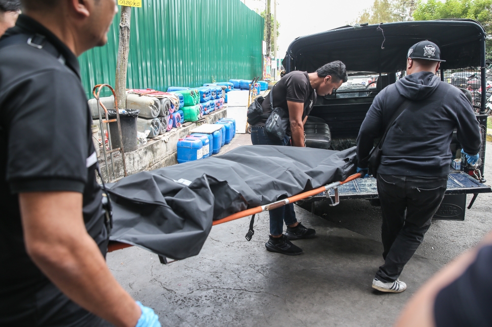 Police personnel carry the body of the suspect in last week's shooting at a Setia Alam shopping mall, who was killed in a police shootout earlier, Klang Port Jetty on February 18, 2025. — Picture by Yusof Mat Isa