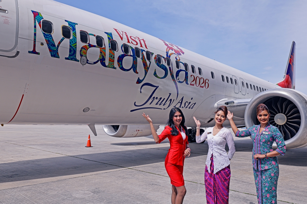 Flight attendants pose with an aircraft featuring the new Visit Malaysia Year 2026 logo during a preview held in conjunction with the Launch Ceremony of the Visit Malaysia Year 2026 Campaign at the MAB Engineering Complex today. — Bernama pic