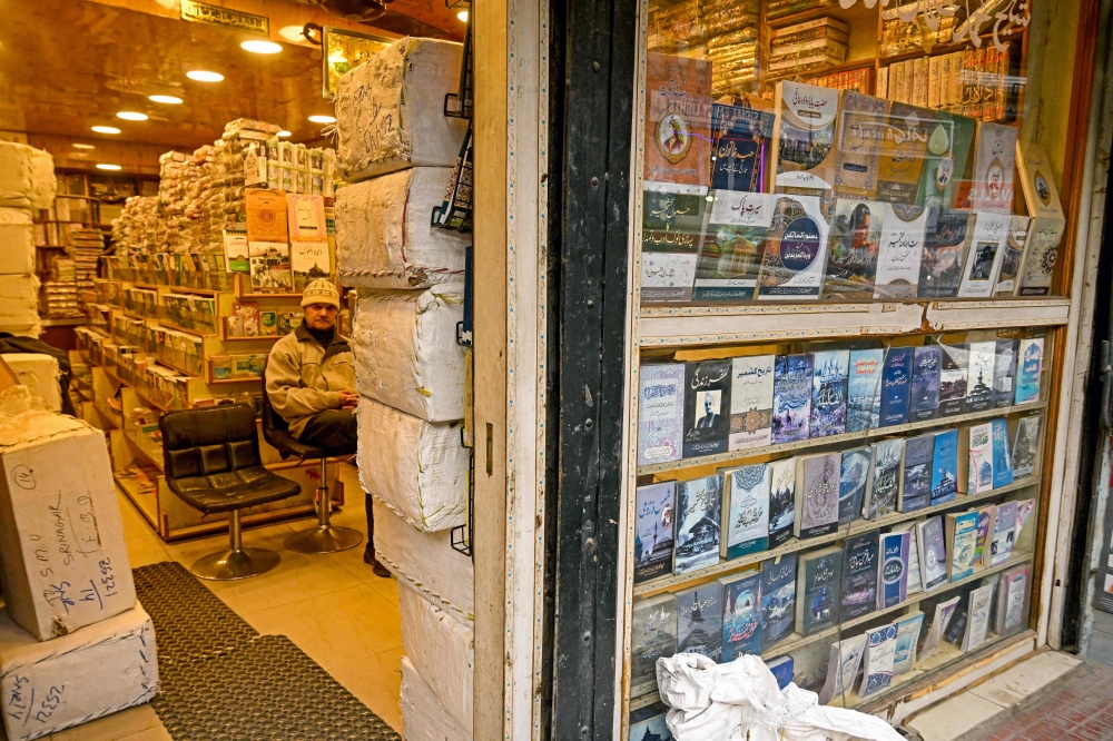 A shopkeeper waits for customers at a bookshop in Srinagar. – Pic by AFP 