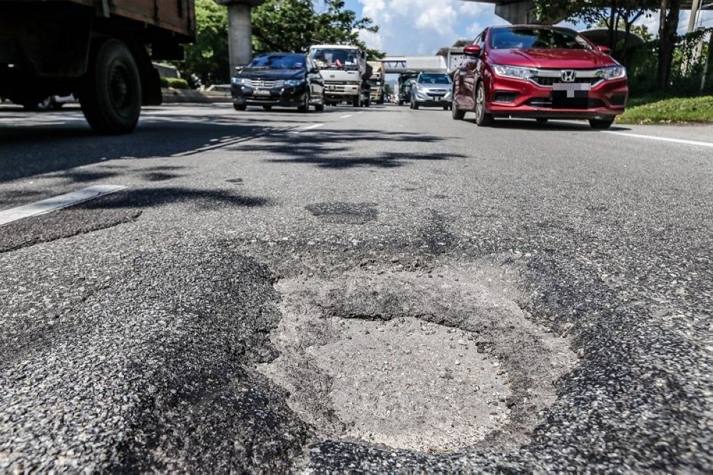 The potholes in the middle of the road can cause accidents to road users, particularly motorcyclists in Kuala Lumpur. — File picture by Hari Anggara