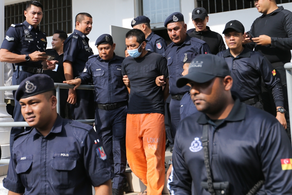 The accused Hafizul Hawari (in face mask and orange trousers) was under heavy police escort while on the way to the Sepang Court for prosecution on April 25,2024. — File picture by Miera Zulyana