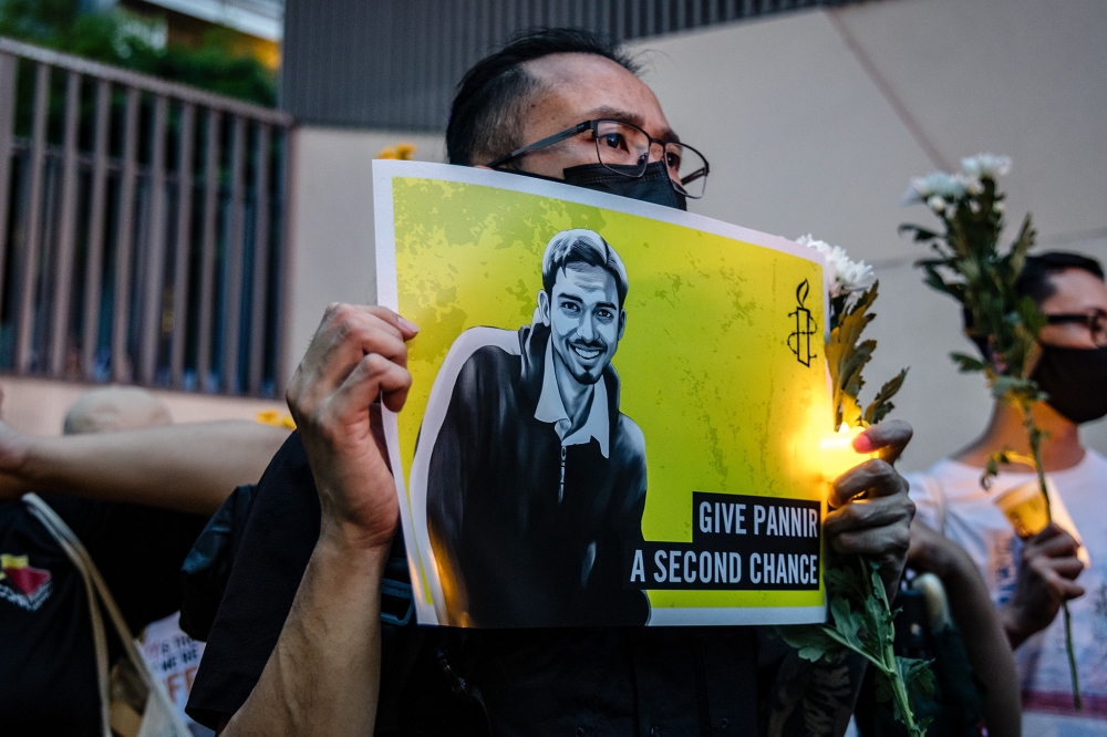A participant holds up a placard during a candlelight vigil against the impending execution of Malaysian death row inmate Pannir Selvam Pranthaman in Singapore outside the Singaporean High Commission in Kuala Lumpur on February 19, 2025. — Picture by Firdaus Latif