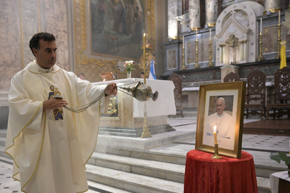 Priest Martin Bourdieu celebrates a mass next to a painting of Pope Francis at the Basilica San Jose de Flores to pray for his health in Buenos Aires on February 19, 2025. — AFP pic