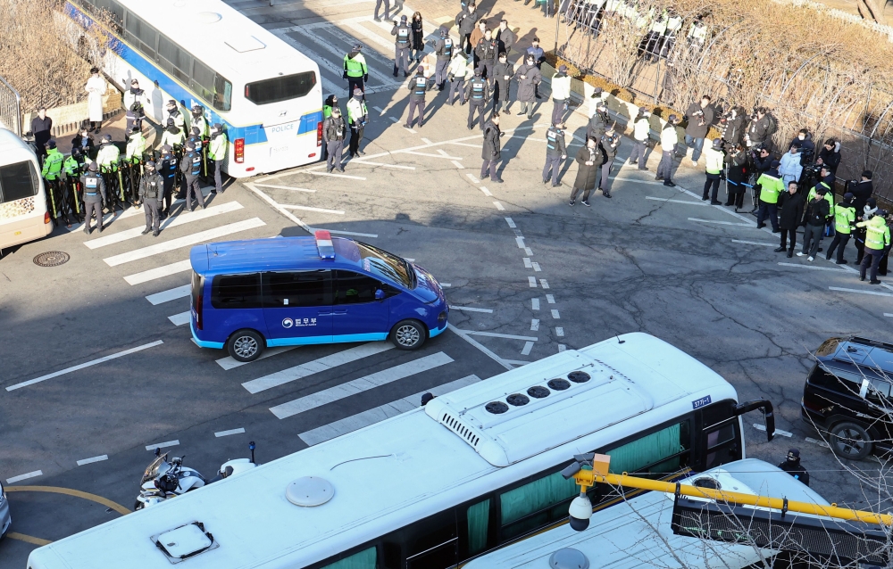 A blue van believed to be transporting impeached South Korean President Yoon Suk Yeol arrives at the Seoul Central District Court in Seoul today. — Pic by AFP