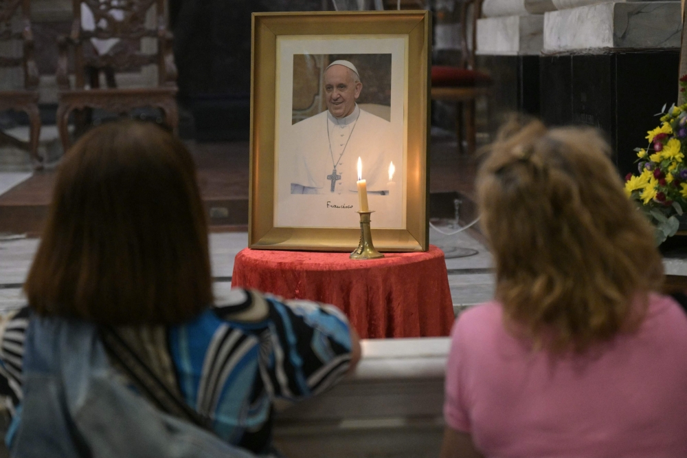 Faithfuls pray in front of a portrait of Pope Francis during a mass at the Basilica San Jose de Flores to pray for his health in Buenos Aires on February 19, 2025. — AFP pic
