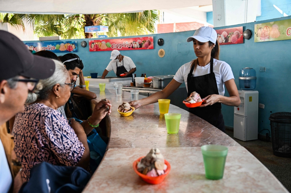 An employee of Coppelia serving customers in Havana. — AFP pic 
