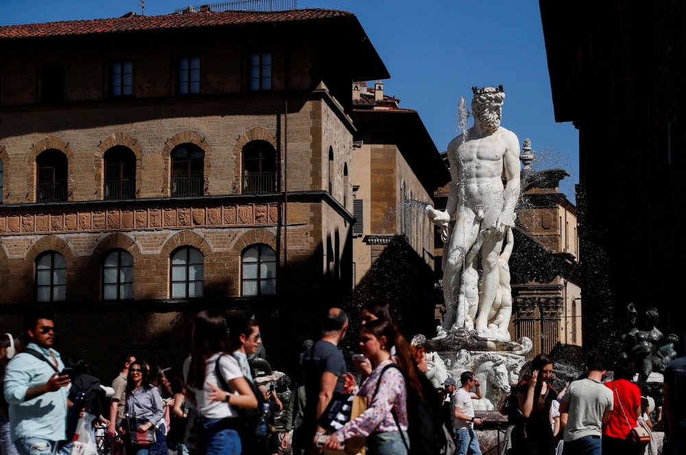 People walk past the Fountain of Neptune in Florence. — Reuters pic