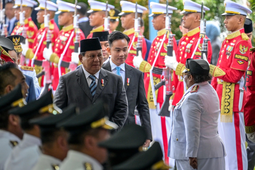 Indonesia's President Prabowo Subianto (left) and Vice President Gibran Rakabuming Raka (centre) arrive for the inauguration of regional heads at the Presidential Palace in Jakarta on February 20, 2025. — Reuters pic