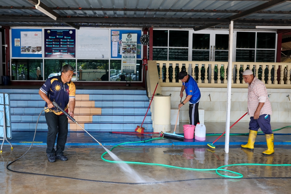Kampung Karak Setia Mosque members cleaning the mosque compound affected by yesterday's floods in Bentong. — Bernama pic 