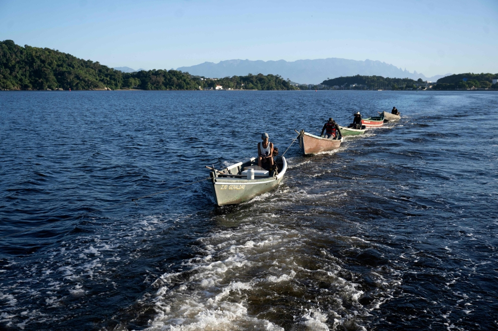 Fishermen sail to the beaches of Pombeba Island to collect garbage in Guanabara Bay, Rio de Janeiro. — AFP pic