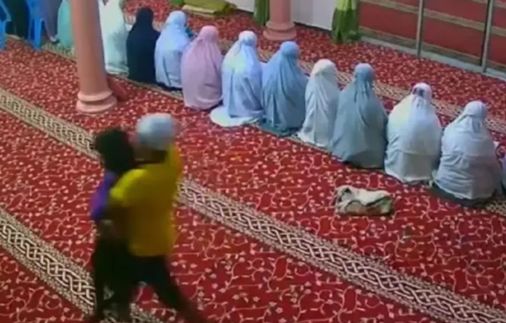 Several videos went viral on social media today showing a man sneaking into the women’s prayer room at a mosque in Batang Kali, Selangor before hugging a girl and taking her out of the room. — Screengrab of video
