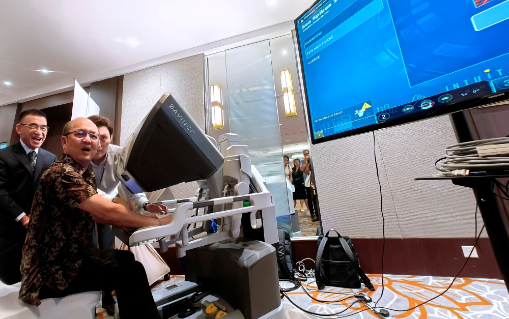 Melaka Health, Human Resources, and Unity Committee Chairman Datuk Ngwe Hee Sem (seated) tests the Da Vinci Xi Robotic Surgery System during its launch in Melaka  February 21, 2025. — Bernama pic