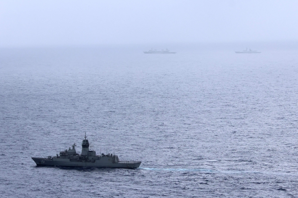 Handout photo taken on Feb 13 released by The Australian Defence Force showing the Royal Australian Navy ship HMAS Arunta (lower left) sailing near the People's Liberation Army-Navy (PLA-N) Fuchi-class replenishment vessel and Weishanhu Jiangkai-class frigate Hengyang in the Tasman Sea. — Pic by AFP