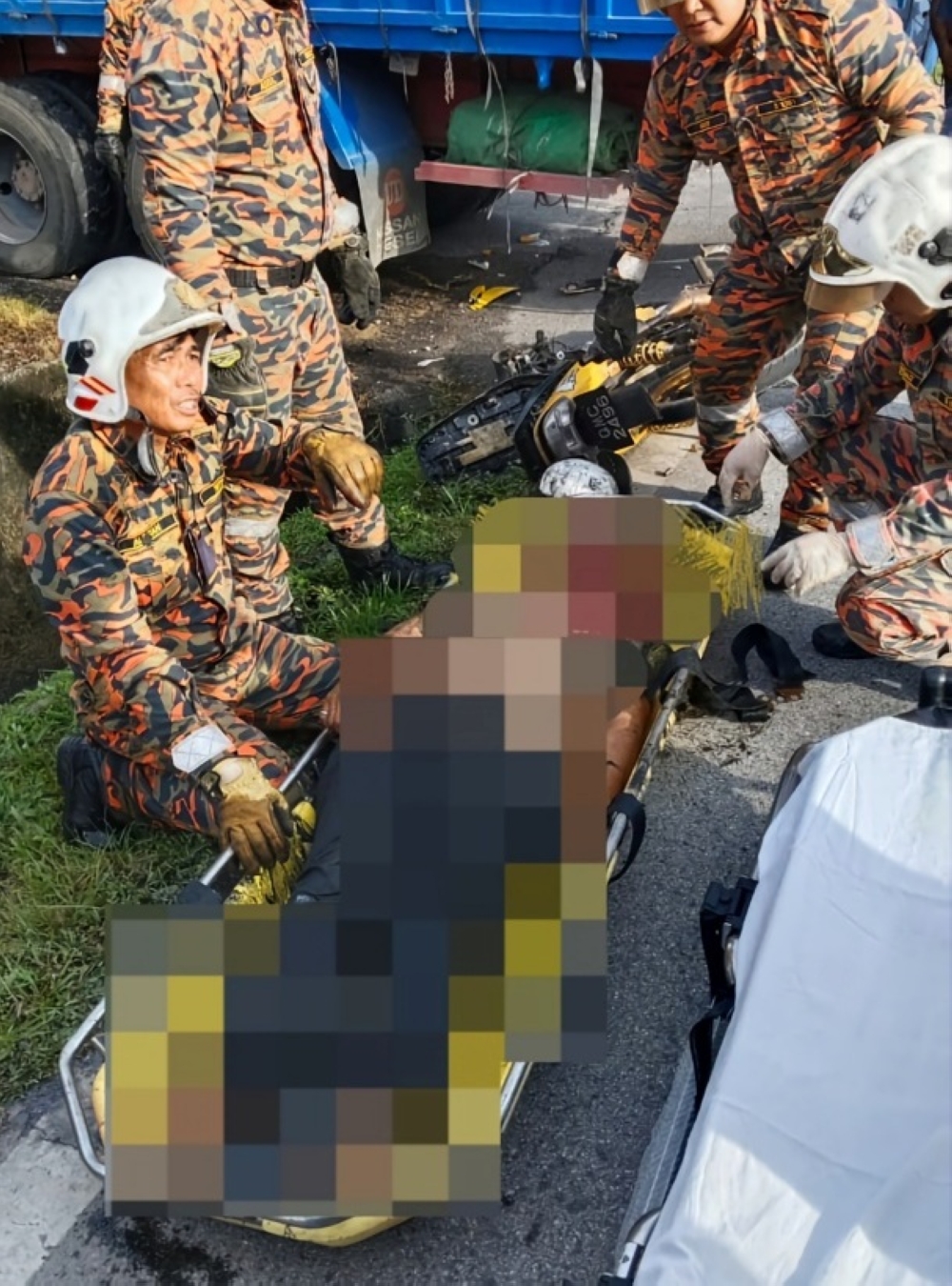 Firefighters recover the victim from the drain at the Jalan Rajang intersection in Sarikei. — Picture courtesy of the Fire and Rescue Department 