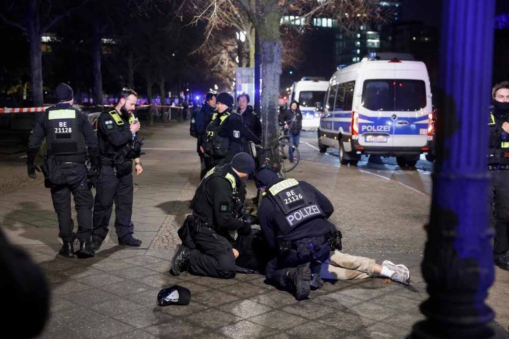 Police apprehend a suspect at the scene where a person was stabbed near the memorial of the murdered jews of Europe in Berlin. — Pic by AFP