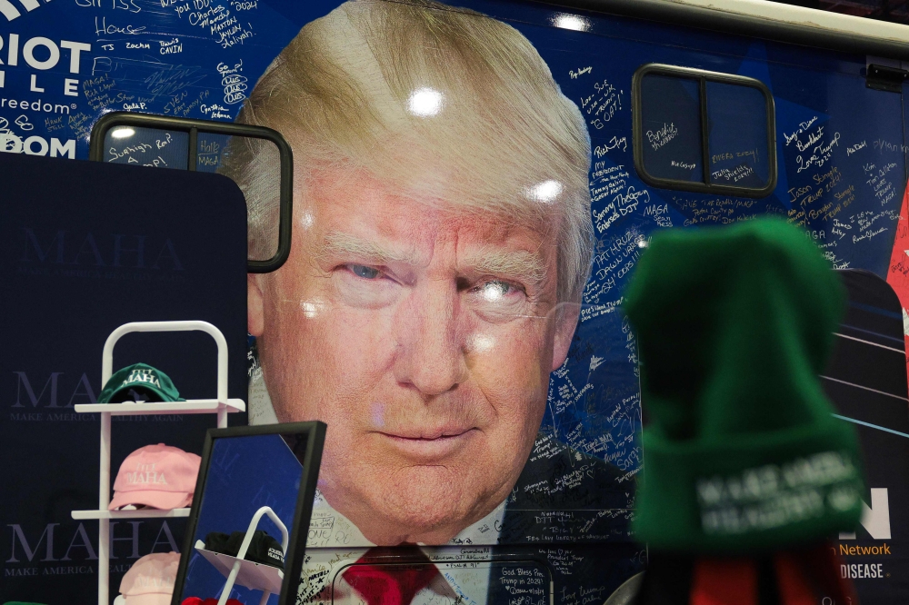 Merchandise sold in front of a bus with U.S. President Donald Trump's face during the Conservative Political Action Conference (CPAC) at the Gaylord National Resort & Convention Center in  Maryland. — Pic by AFP 