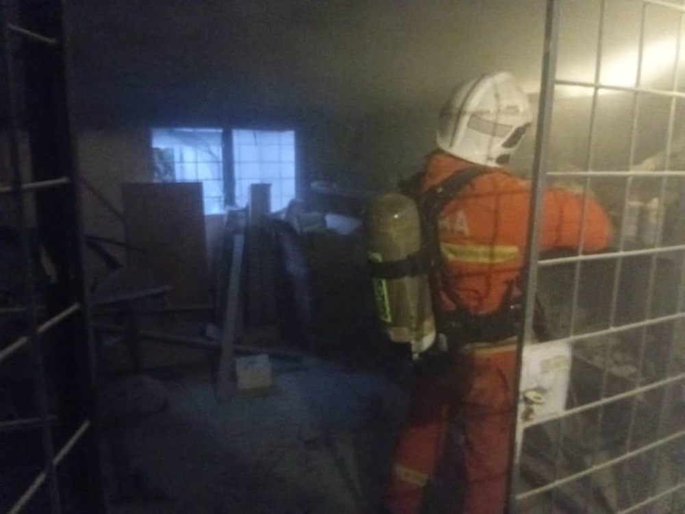 Firefighters putting out the fire in a storeroom at SMK Tatau. — Picture courtesy of the Fire and Rescue Department 