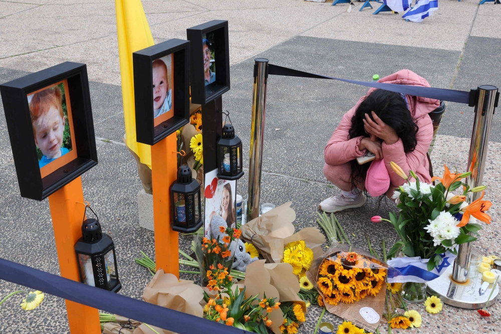  A woman mourns next to pictures of portraits of late Israeli hostages Ariel and Kfir Bibas, Oded Lifshitz and Shiri Bibas as people gather at Hostages Square in Tel Aviv, ahead of seventh hostage-prisoner release. — Pic by AFP