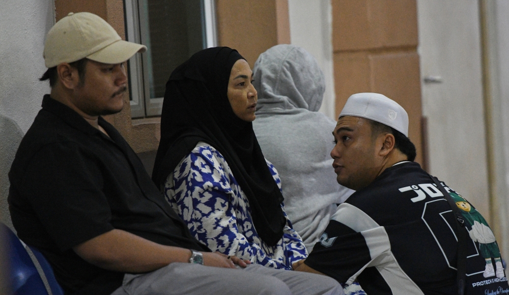 The family of the late Ayer Kuning assemblyman Ishsam Shahruddin, including his widow Rozlita Abdullah wait at the Forensic Medicine Department of Penang Hospital following his sudden death on February 22, 2025. — Bernama pic