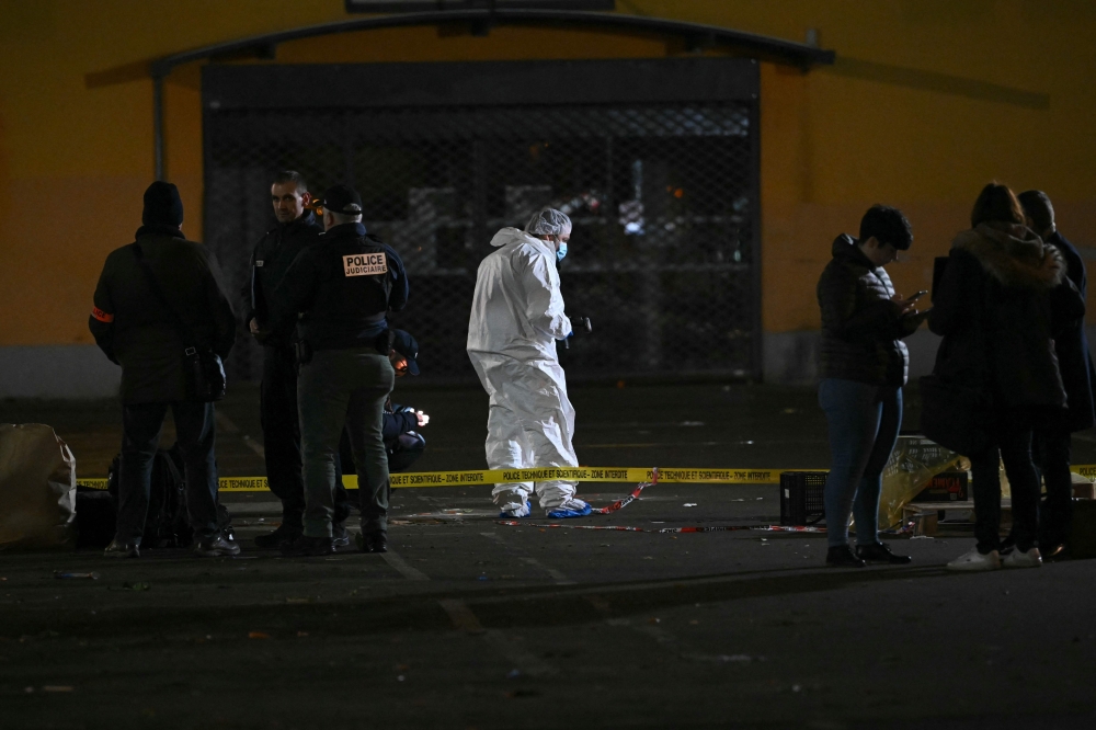 French forensic police work on the site of a knife attack where a man is suspected of killing one person and seriously wounding two police officers in Mulhouse. — Pic by AFP