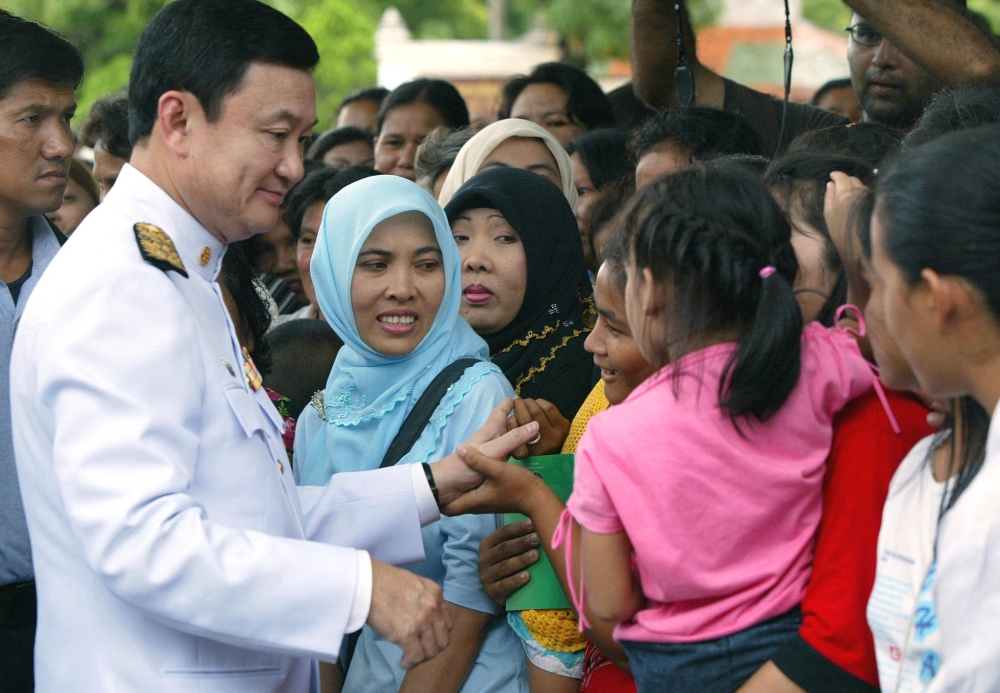 Then Thai Prime Minister Thaksin Shinawatra meeting with villagers in Tak Bai, southern Thailand, on November 7, 2004. — AFP file pic