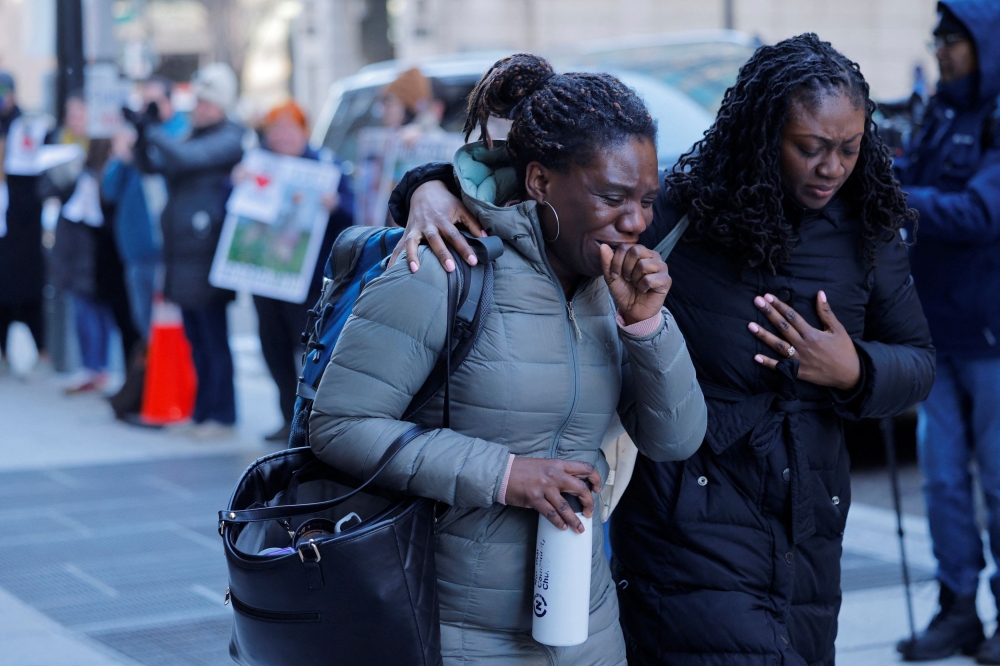 Recently fired US Agency for International Development (USAID) staff react as they leave work and are applauded by former USAID staffers and supporters during a sendoff outside USAID offices in Washington, D.C. February 21, 2025. — Reuters pic  
