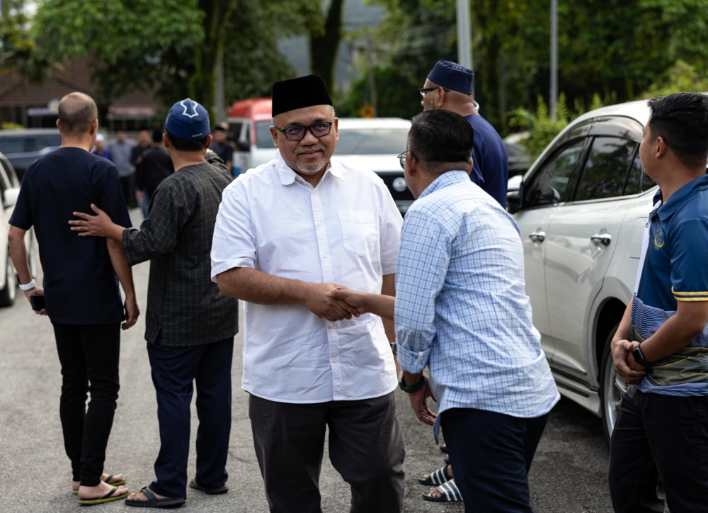Perak State Assembly Speaker Datuk Mohamad Zahir Abdul Khalid pays his respects to the late Ayer Kuning assemblyman Ishsam Shahruddin at Desa Seri Ampang, Ipoh yesterday. — Bernama pic