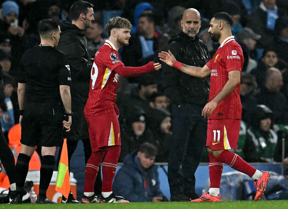 Manchester City's Spanish manager Pep Guardiola looks on as Liverpool's Egyptian striker #11 Mohamed Salah (right) leaves the pitch after being substituted off for Liverpool's English midfielder #19 Harvey Elliott during the English Premier League football match between Manchester City and Liverpool at the Etihad Stadium in Manchester, north west England, on February 23, 2025. — AFP pic
