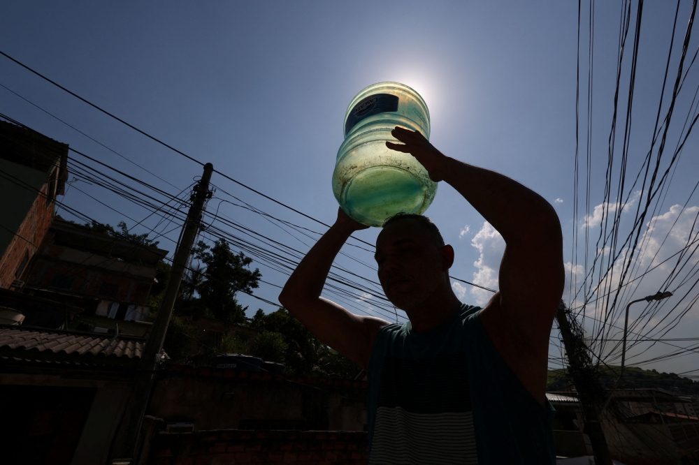 Barber Renato Rodrigues, 41, carries an empty gallon to fetch water after running out at home amid an extreme heatwave in Nova Iguacu, Rio de Janeiro state, Brazil, February 18, 2025. Representatives of nearly 200 countries gather Monday to continue fraught negotiations on the timing and content of the UN’s next blockbuster assessment of global warming science. The meeting in the Chinese city of Hangzhou comes on the heels of the hottest year on record and rising alarm over the pace of warming.  — Reuters pic 