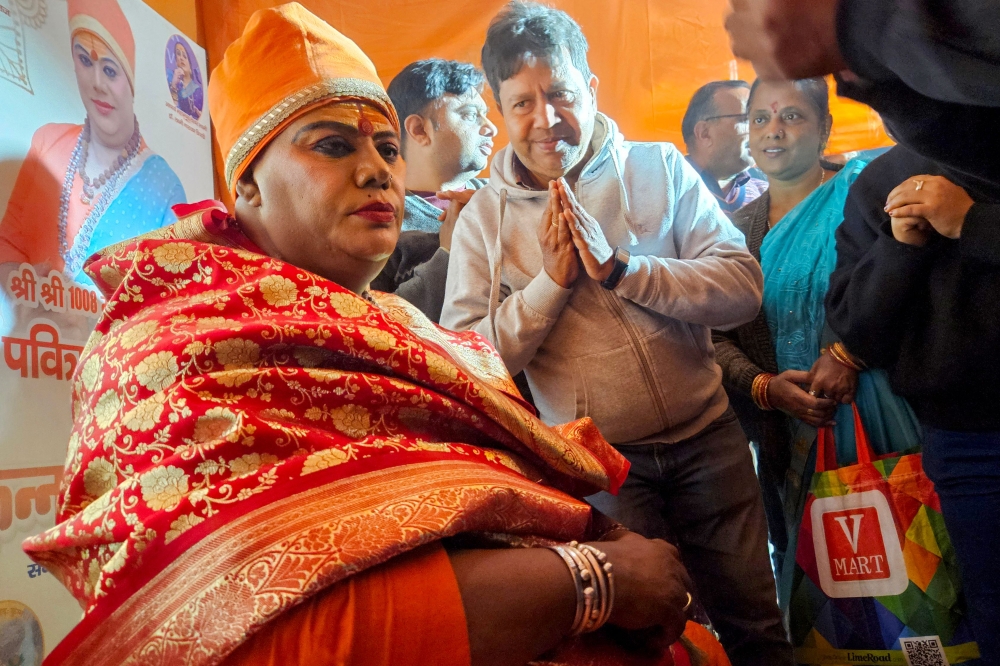 A transgender person from ‘Kinnar akhada’ a monastic Hindu order, blesses pilgrims during the Maha Kumbh Mela festival in Prayagraj. — Pic by AFP