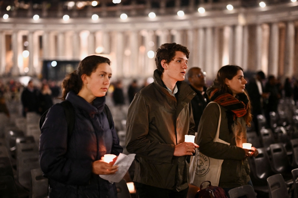 People take part in a prayer service in St. Peter’s Square as Pope Francis continues treatment at Gemelli Hospital. — Reuters pic