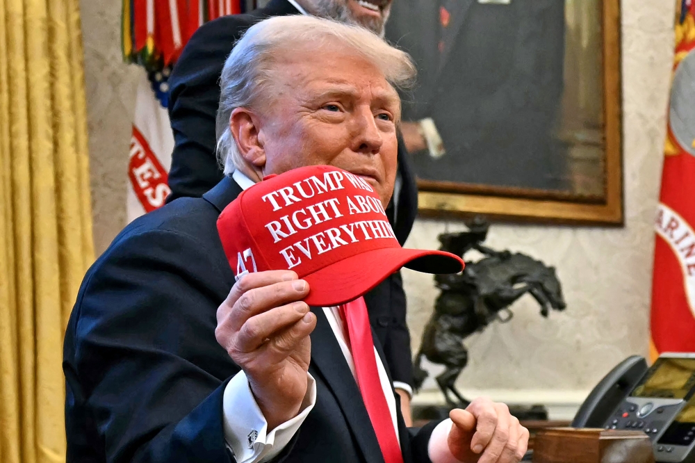 US President Donald Trump holds a hat reading ‘Trump was right about everything’ after signing an Executive Order at the Oval Office of the White House in Washington, DC on February 25, 2025. — AFP pic 