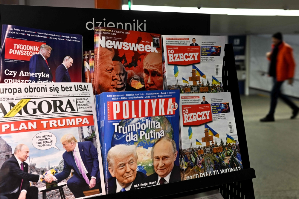 A man walks through an underground passage past a kiosk selling magazines with covers depicting Russia's President Vladimir Putin and US President Donald Trump in Warsaw on February 25, 2025. — AFP pic
