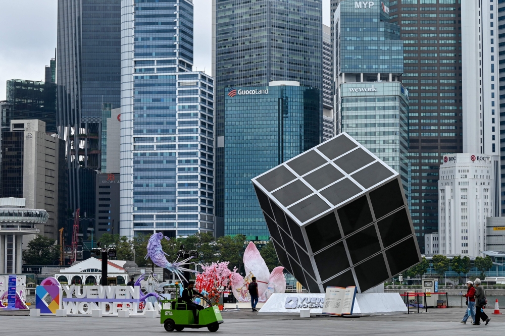 File picture of people walking along the promenade next to installations of the Yuewen Wonderland event at Marina Bay in Singapore on February 18, 2025. Singapore will invest S$60 million (RM198.6 million) over the next two years to further catalyse research and development in space technologies and support their subsequent translation. — AFP pic 